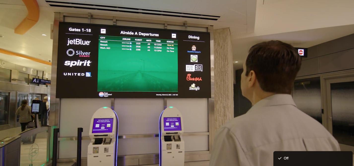 Passenger reading digital flight information sign at an airport