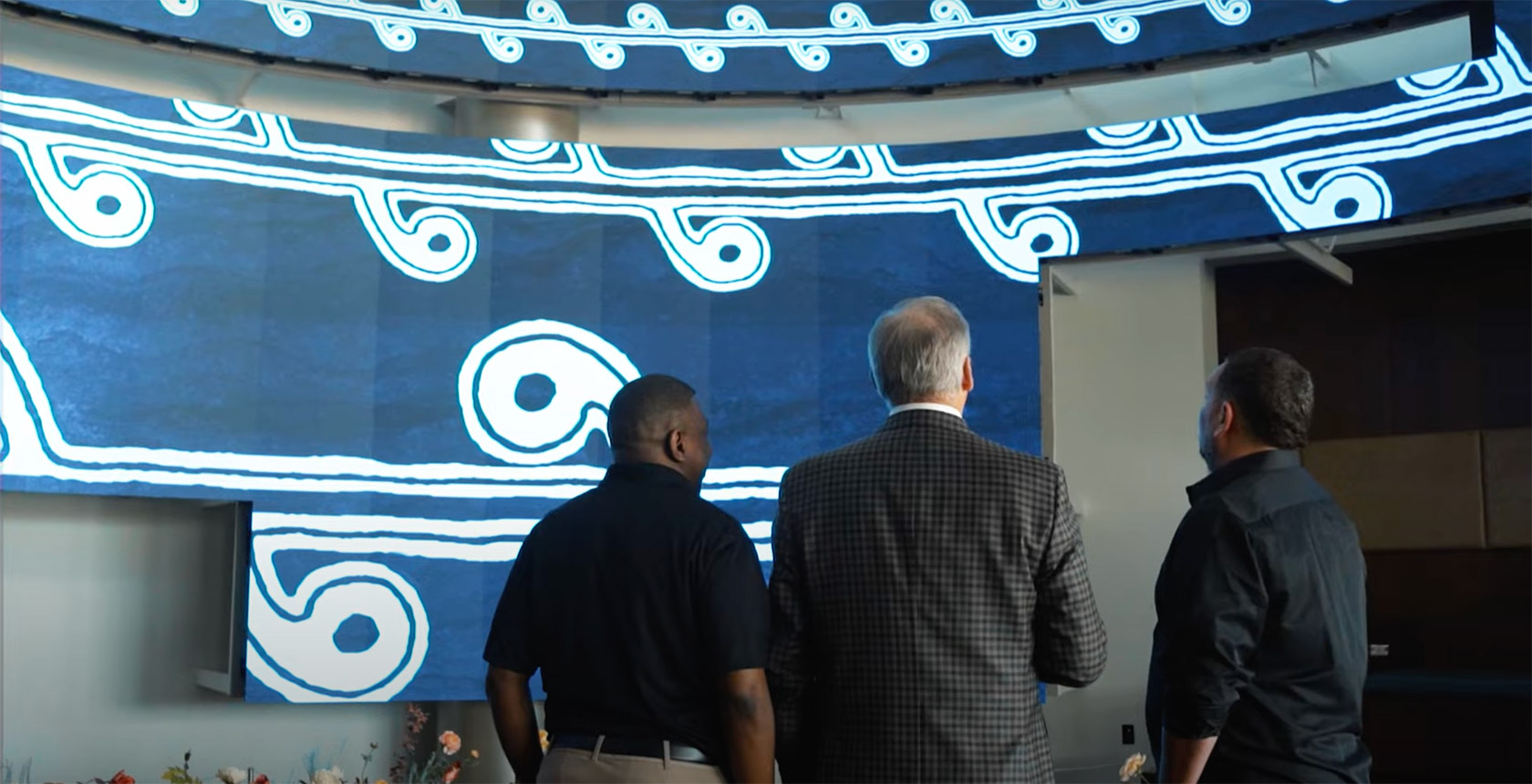 3 men looking at the Absen projected images